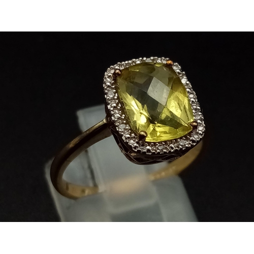 1265 - A 9K yellow gold ring with a large mix cut yellow beryl (app. 6 carats) surrounded by a halo of diam... 