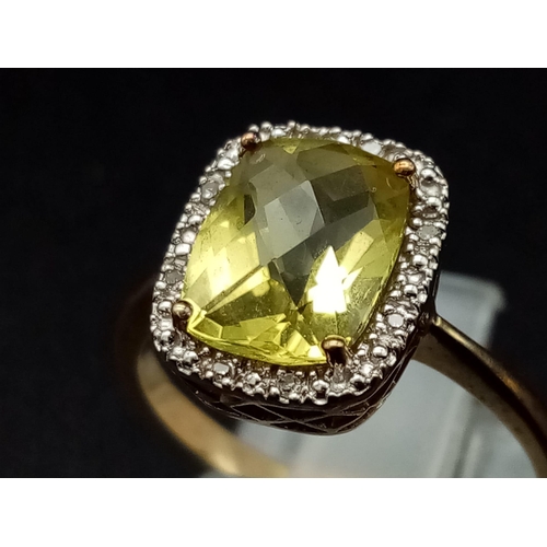 1265 - A 9K yellow gold ring with a large mix cut yellow beryl (app. 6 carats) surrounded by a halo of diam... 