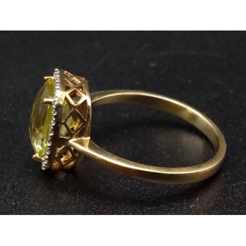 1265 - A 9K yellow gold ring with a large mix cut yellow beryl (app. 6 carats) surrounded by a halo of diam... 