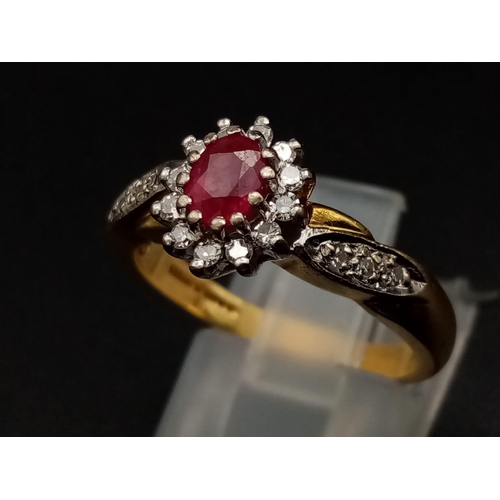 1269 - An 18K yellow gold ring with an oval cut ruby surrounded by a halo of diamonds with further diamonds... 