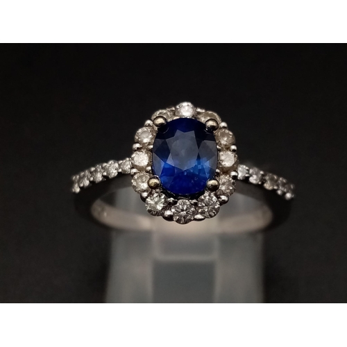 1277 - An 18K white gold ring with a beautiful, natural, oval cut, blue sapphire, surrounded by a halo of d... 