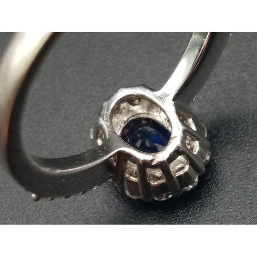 1277 - An 18K white gold ring with a beautiful, natural, oval cut, blue sapphire, surrounded by a halo of d... 