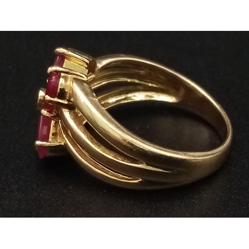 1285 - A 9K yellow gold ring with three bands supporting four oval cut rubies. Ring size: N, weight: 4.29 g... 