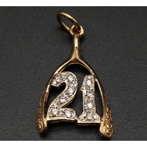 549 - A 9K yellow gold pendant/charm in the shape of a wishbone with the number 21 covered with cubic zirc... 