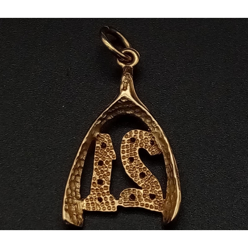 549 - A 9K yellow gold pendant/charm in the shape of a wishbone with the number 21 covered with cubic zirc... 