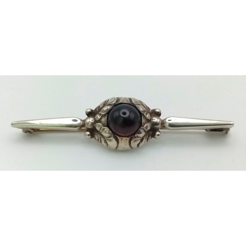 325 - A Superb Early Georg Jensen Denmark Sterling Silver and Garnet Cabochon

Brooch 6cm Wide, 5.31 Grams