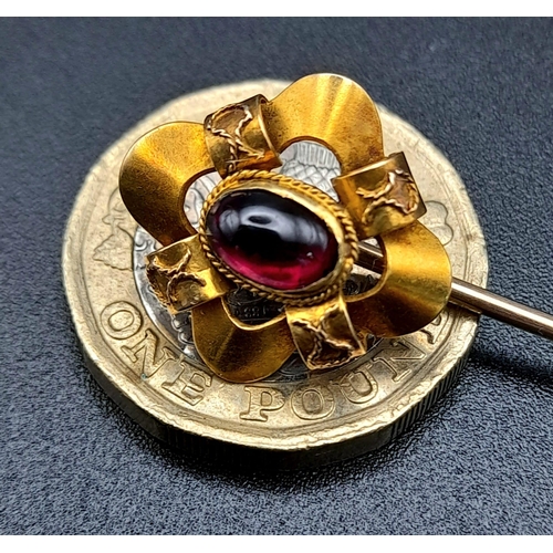 1282 - A Victorian High-Karat Gold and Almadine Cabochon Long Stick Pin. 8cm. 3.23g total weight. Comes in ... 