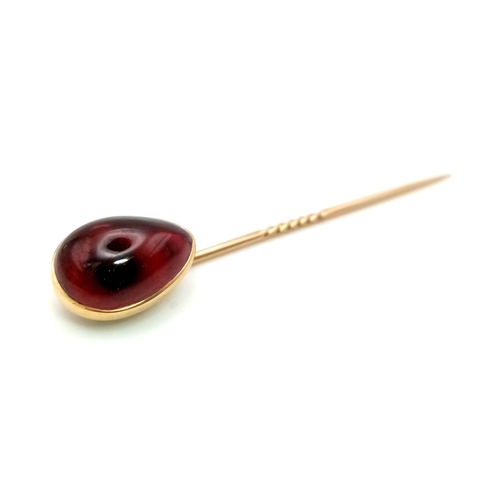 1293 - A high carat stick pin  with tear drop shaped garnet. Length: 7.5 cm, weight: 4 g.