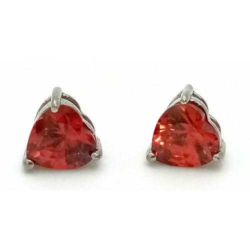 814 - A sterling silver lot with red cubic zirconia including a pair of heart shaped earrings, a heart sha... 