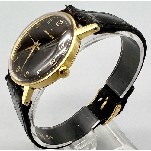 1572 - A VINTAGE 18K GOLD ETERNA-MATIC GENTS WATCH WITH MANUAL MOVEMENT , STRIKING BLACK DIAL AND BLACK LEA... 