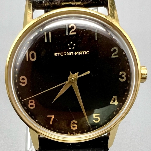 1572 - A VINTAGE 18K GOLD ETERNA-MATIC GENTS WATCH WITH MANUAL MOVEMENT , STRIKING BLACK DIAL AND BLACK LEA... 