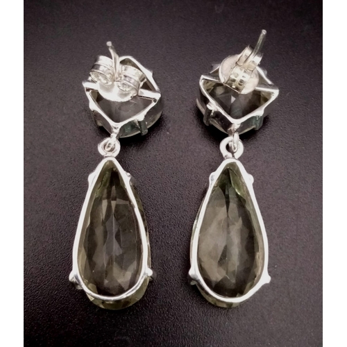 1561 - 925 Silver Pear Cut Amethyst Dangler Earrings with matching Pendant. Total Weight 20.82g