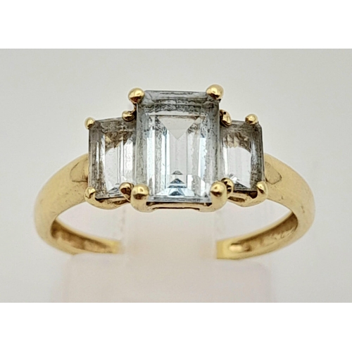 1543 - A 9K Yellow Gold Emerald-Cut Three Stone Aquamarine Ring. 
Size L. 1.65g total weight.