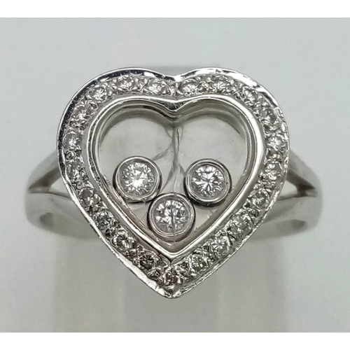 1523 - AN 18K WHITE GOLD AND FLOATING DIAMOND HEART RING.  5.3gms   size J