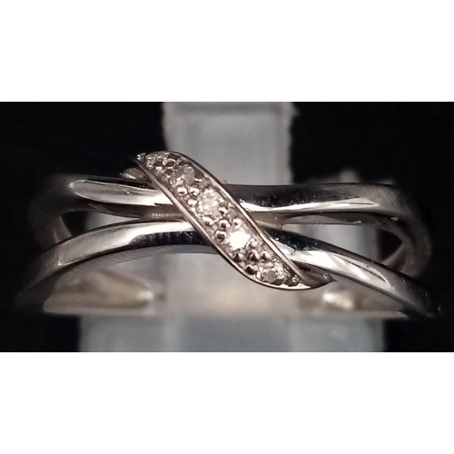 1551 - A 9K White Gold Diamond Crossover Ring. Size M/N. 2.03g total weight.