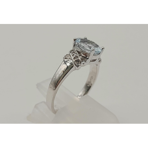 1599 - A 9K WHITE GOLD RING WITH COLOURED OVAL CENTRE STONE AND ORNATE SHOULDERS.2.9gms   size N.