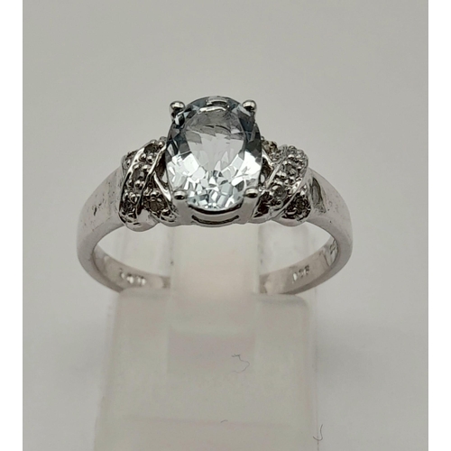 1599 - A 9K WHITE GOLD RING WITH COLOURED OVAL CENTRE STONE AND ORNATE SHOULDERS.2.9gms   size N.