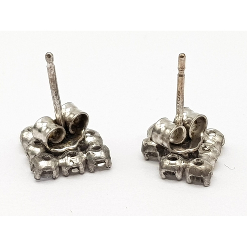 1233 - A 9K white gold pair of earrings with a cluster of fine diamonds. Total weight: 1.18 g.