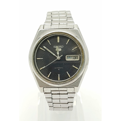 1410 - A Vintage Seiko 5 Automatic Gents Watch. Stainless steel strap and case - 37mm. Black dial with day/... 