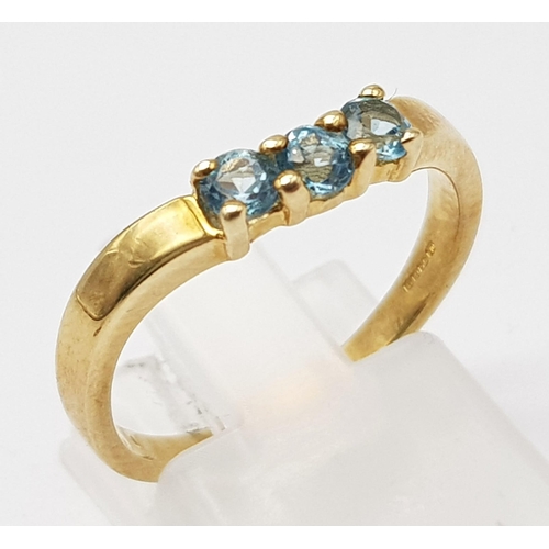 727 - 9K YELLOW GOLD TOPAZ 3 STONE RING. WEIGHS 2.5G. SIZE N