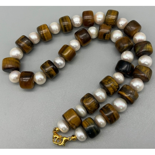 391 - A Tigers Eye Rondelle Bead and Cultured Freshwater Pearl Necklace. Gilded clasp. 44cm.