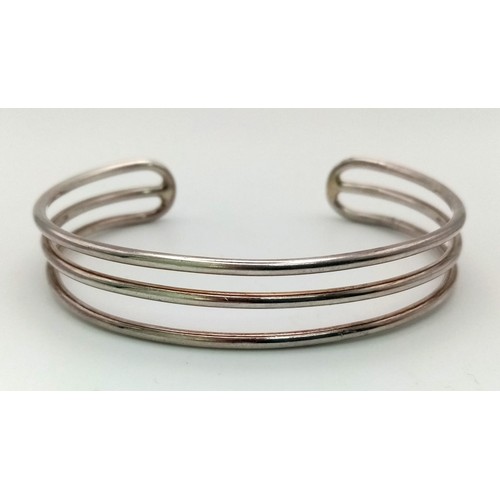 821 - A unisex, three row, sterling silver cuff bangle. Weight: 23.9 g.