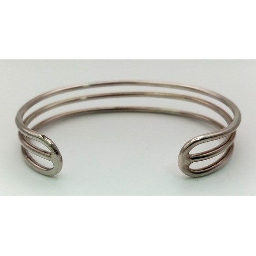 821 - A unisex, three row, sterling silver cuff bangle. Weight: 23.9 g.