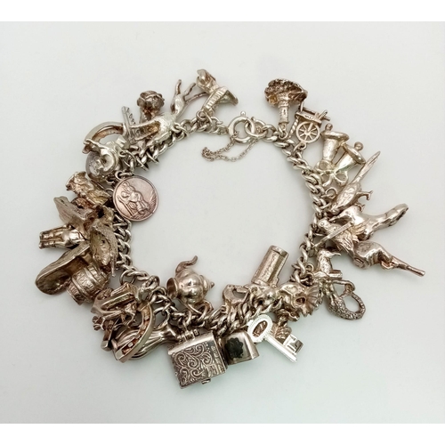 228 - A Vintage 925 Silver Charm Bracelet. Over 20 eclectic charms
including a horse shoe and rocking hors... 