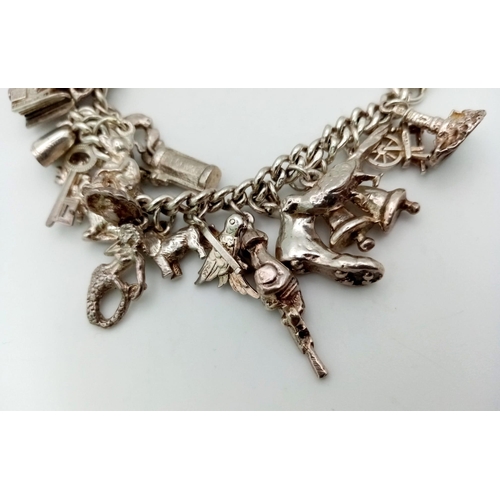 228 - A Vintage 925 Silver Charm Bracelet. Over 20 eclectic charms
including a horse shoe and rocking hors... 