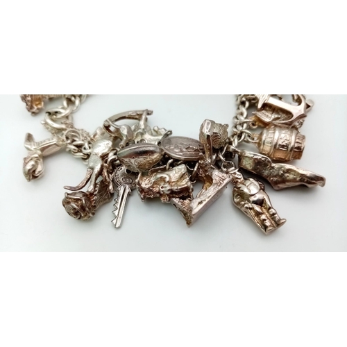 228 - A Vintage 925 Silver Charm Bracelet. Over 20 eclectic charms
including a horse shoe and rocking hors... 