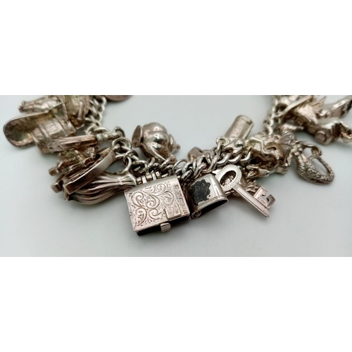 228 - A Vintage 925 Silver Charm Bracelet. Over 20 eclectic charms
including a horse shoe and rocking hors... 