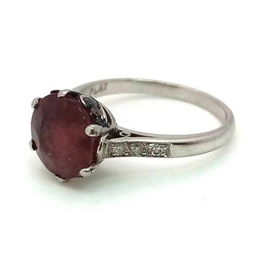 158 - An 18K White Gold, Ruby and Diamond Ring. A 3.3ct round ruby with six brilliant round cut diamonds o... 