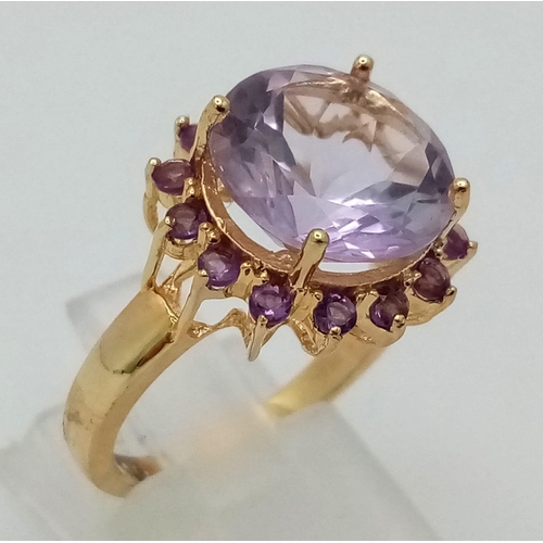 1557 - A Gold Plated 925 Silver Amethyst Ring. Central amethyst surrounded by a halo of smaller amethysts. ... 