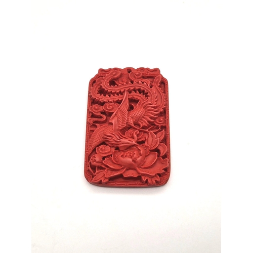 1542 - A Hand-Carved Cinnabar Dragon Rectangular Pendant. 6cm