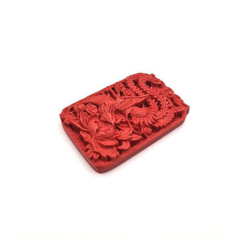 1542 - A Hand-Carved Cinnabar Dragon Rectangular Pendant. 6cm