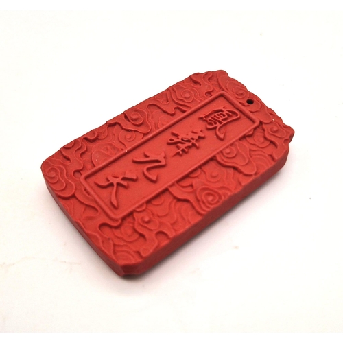 1542 - A Hand-Carved Cinnabar Dragon Rectangular Pendant. 6cm