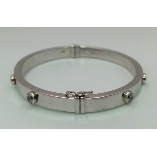 69 - 9k white gold Cartier style bangle set with 8 CZ stones, Total Weight 8.2g, 6.5cm wide