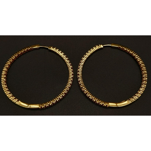 121 - A 9 K yellow gold, pink stone set, hoop earrings, weight: 8.4 g.