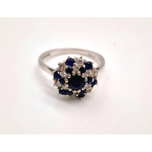 156 - An 18 K white gold swirl cluster ring with diamonds and sapphires. Ring size: M1/2, weight: 3.2 g.