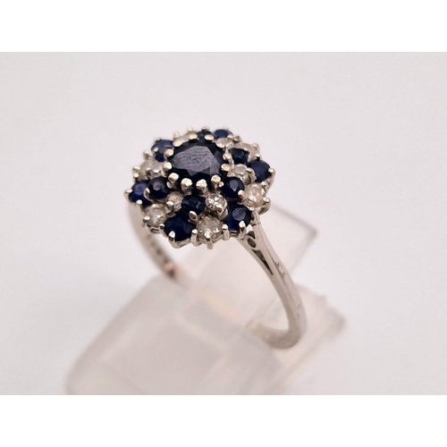 156 - An 18 K white gold swirl cluster ring with diamonds and sapphires. Ring size: M1/2, weight: 3.2 g.