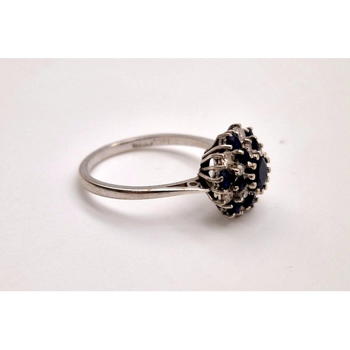 156 - An 18 K white gold swirl cluster ring with diamonds and sapphires. Ring size: M1/2, weight: 3.2 g.