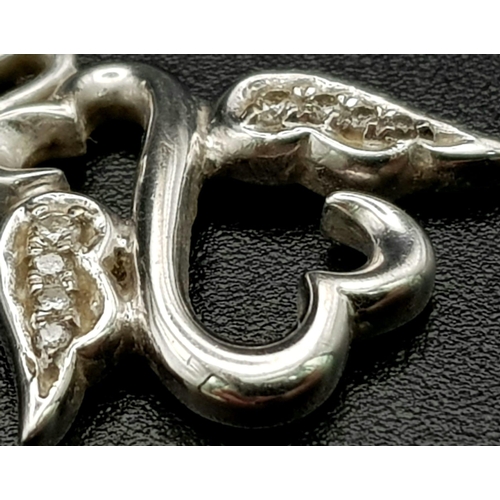 191 - An 18 K white gold, diamond set, pair of swans in a heart shaped pendant/charm. Weight: 2.2. g.