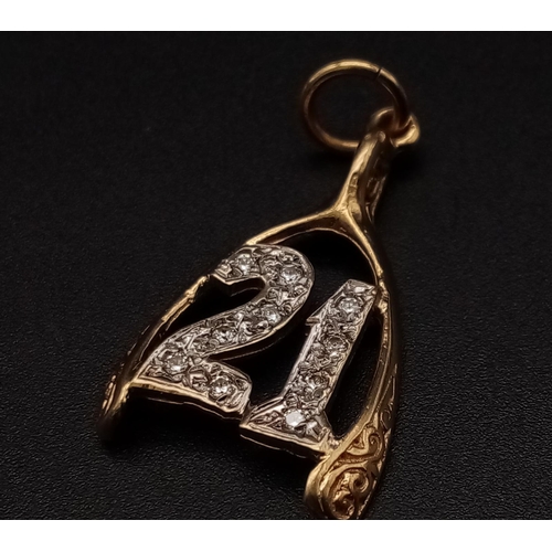 194 - A 9K yellow gold pendant/charm in the shape of a wishbone with the number 21 covered with cubic zirc... 