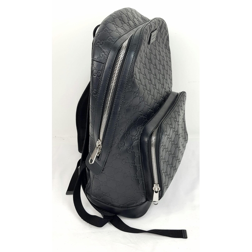 186 - A Gucci Signature GG Black Leather Backpack. Outer zipped compartment. Roomy interior with clip flap... 