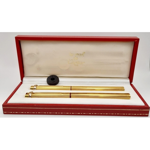 132 - Two Must de Cartier Gold Plated Pens in a Cartier Case. A fountain pen and a Ballpoint pen. Both 14c... 