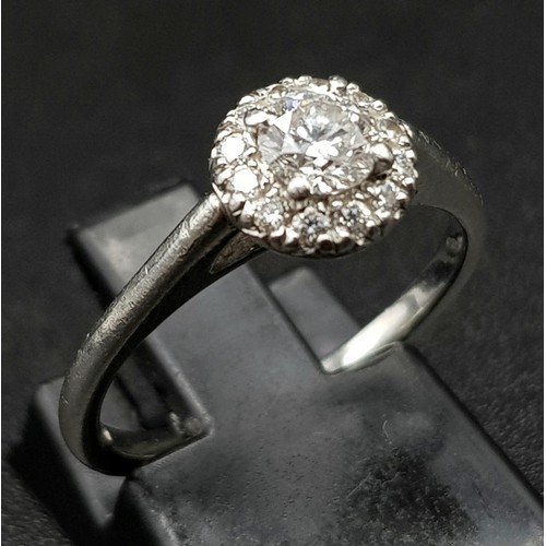 110 - An 18K White Gold and Diamond Ring. 0.25ct brilliant round cut central diamond (approx) surrounded b... 