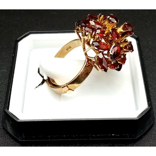 105 - A spectacular, 14 K yellow gold ring, profusely encrusted with twenty four, high quality garnets of ... 