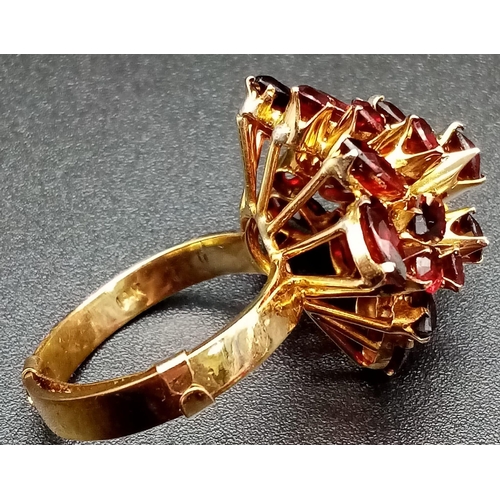 105 - A spectacular, 14 K yellow gold ring, profusely encrusted with twenty four, high quality garnets of ... 