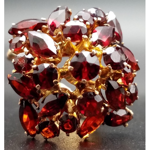 105 - A spectacular, 14 K yellow gold ring, profusely encrusted with twenty four, high quality garnets of ... 