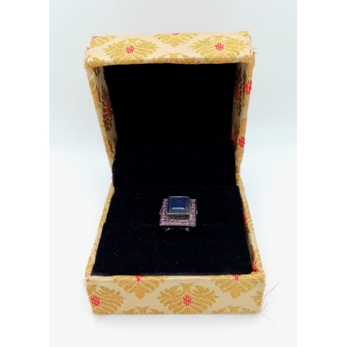 525 - A Blue Sapphire Ring set with Rubies. Rectangular step cut Sapphire. Set In Oxidised 925 Sterling si... 